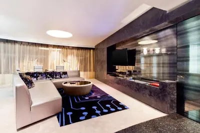 a living room with a couch and a tv at W Bangkok Hotel in Bangkok