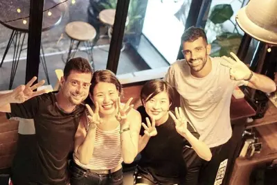 a group of people making the peace sign with their hands at Bangkok Nomad Hostel in Bangkok