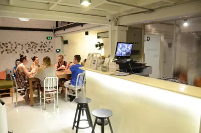 a group of people sitting at a counter in a restaurant at Bangkok Nomad Hostel in Bangkok