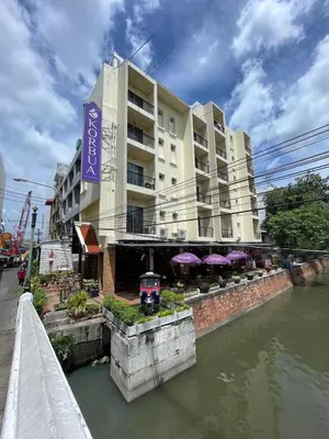 a building next to a body of water at Korbua House in Bangkok