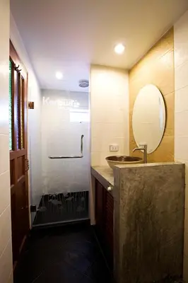 a bathroom with a sink and a mirror at Korbua House in Bangkok