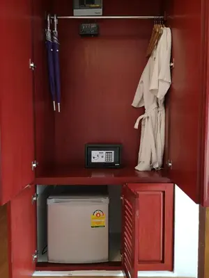 a red cabinet with a desk with a microwave and a cooler at Korbua House in Bangkok