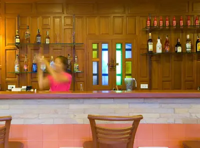 a woman sitting at a bar in a restaurant at Korbua House in Bangkok