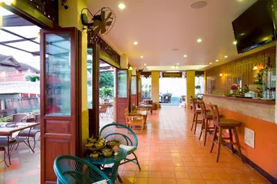 a restaurant with tables and chairs and a bar at Korbua House in Bangkok