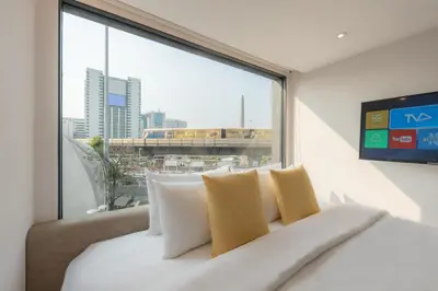 a bed in a room with a large window at Yello Rooms Hotel Victory Monument in Bangkok