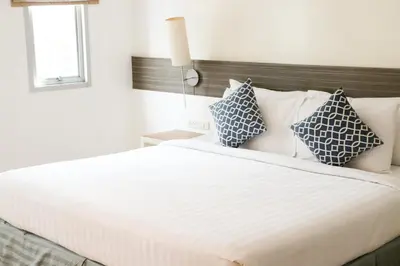 a bedroom with a large bed with blue and white pillows at The Mini R Ratchada in Bangkok