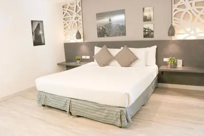 a bedroom with a large bed with white sheets and pillows at The Mini R Ratchada in Bangkok