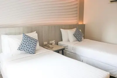 a room with two beds and a small table at The Mini R Ratchada in Bangkok