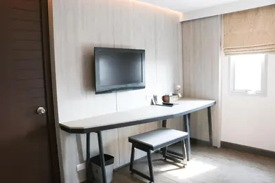 a room with a desk with a tv on the wall at The Mini R Ratchada in Bangkok