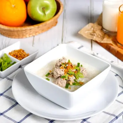 a bowl of soup on a table with fruits and vegetables at The Mini R Ratchada in Bangkok