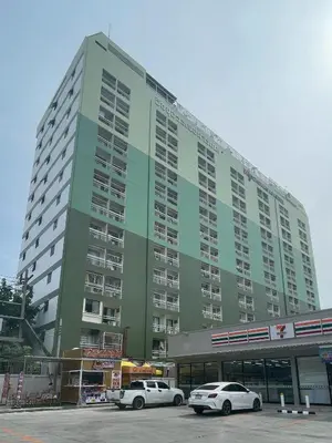 two cars parked in front of a large building at Witchuwan Apartel in Bangkok