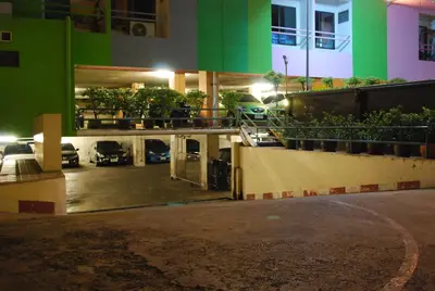 a parking lot in front of a building at night at Witchuwan Apartel in Bangkok
