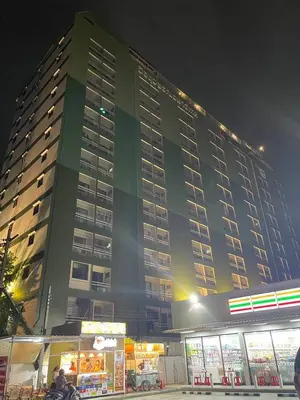 a large green building with a food stand in front of it at Witchuwan Apartel in Bangkok