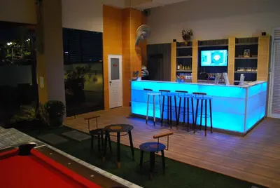 a blue bar with stools in a room at Witchuwan Apartel in Bangkok