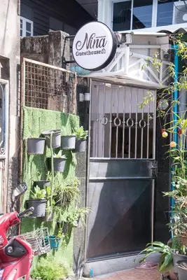 a garage door with plants on the side of a house at ninaguesthouse in Bangkok