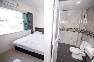 a small bathroom with a toilet and a shower at ninaguesthouse in Bangkok