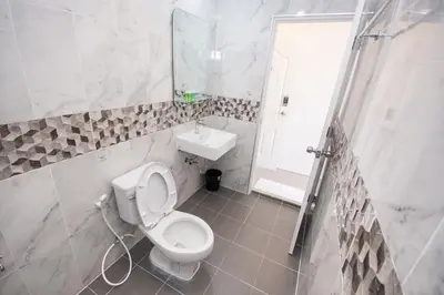 a white bathroom with a toilet and a sink at ninaguesthouse in Bangkok