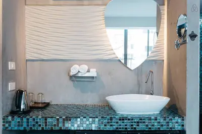 a bathroom with a tub and a sink and a mirror at Blutique Hotel in Bangkok