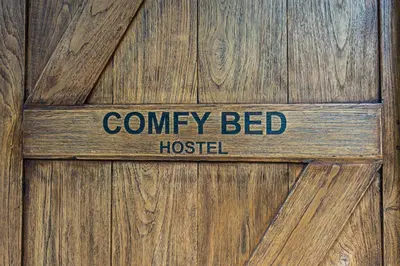 a wooden door with a sign that reads county bed hospital at Comfy Bed Hostel in Bangkok