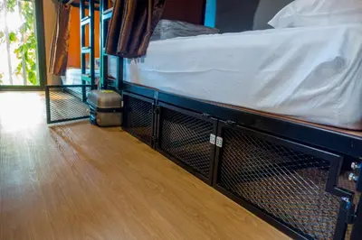 a bed in a room with a wooden floor at Comfy Bed Hostel in Bangkok