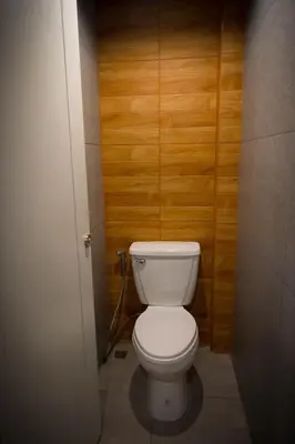 a bathroom with a white toilet in a wooden wall at Comfy Bed Hostel in Bangkok