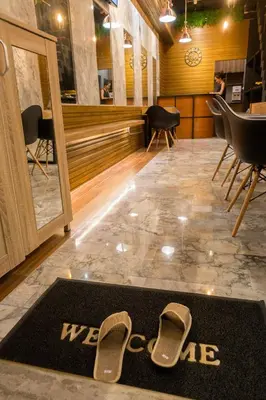 a welcome mat with a pair of shoes on the floor at Comfy Bed Hostel in Bangkok