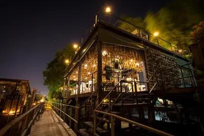 a building with chairs and lights at night at Bangkok Tree House Bang Kachao in Bangkok