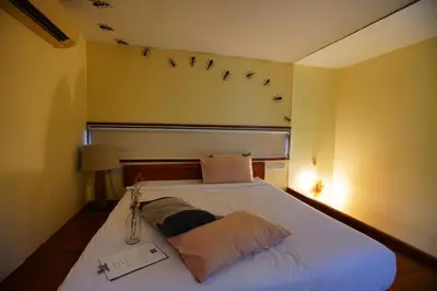 a bedroom with a bed with birds on the wall at Bangkok Tree House Bang Kachao in Bangkok