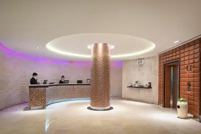 a lobby with a reception desk and a pillar at The Davis Bangkok in Bangkok