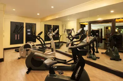 a gym with treadmills and ellipticals in a room at The Davis Bangkok in Bangkok