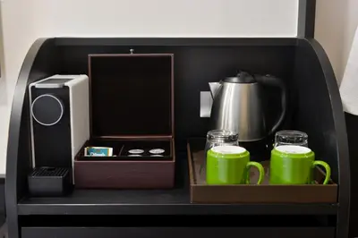 a tray with two green mugs and a tea set at Oakwood Hotel & Residence Bangkok in Bangkok