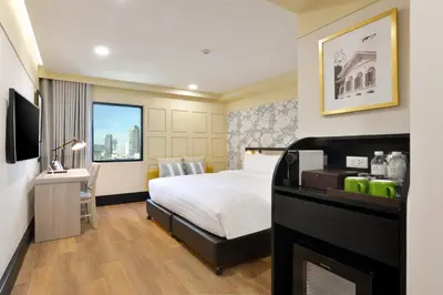 a hotel room with a bed and a television at Oakwood Hotel & Residence Bangkok in Bangkok