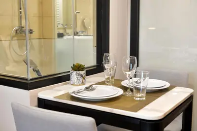 a dining room table with glasses and plates on it at Oakwood Hotel & Residence Bangkok in Bangkok