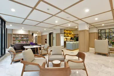 a lobby with chairs and tables in a building at Oakwood Hotel & Residence Bangkok in Bangkok