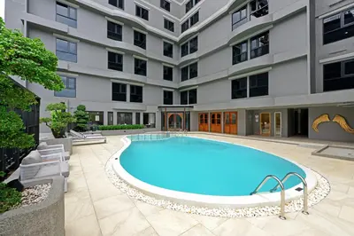 a swimming pool in front of a building at Oakwood Hotel & Residence Bangkok in Bangkok