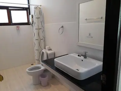 a white bathroom with a sink and a toilet at House 23 Guesthouse in Bangkok