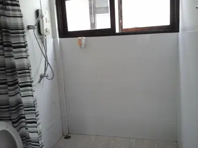a bathroom with a shower with a toilet and a window at House 23 Guesthouse in Bangkok