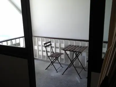 a table and two chairs sitting on a balcony at House 23 Guesthouse in Bangkok