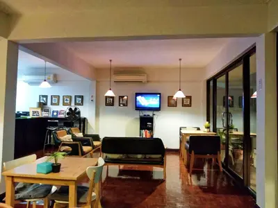 a living room with a table and chairs and a television at House 23 Guesthouse in Bangkok