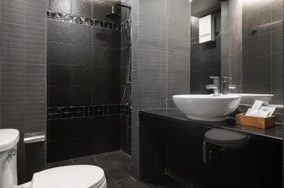 a bathroom with a white sink and a toilet at G Boutique Silom Hotel in Bangkok