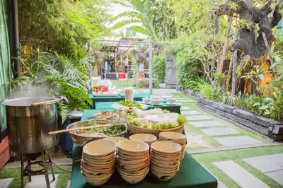 a table with plates of food and a pot at The Loft Resort Bangkok in Bangkok