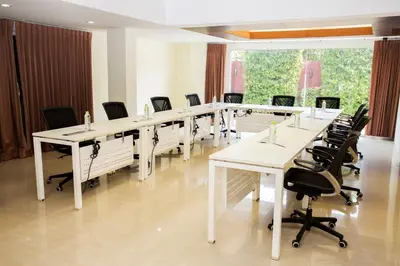 a large conference room with white tables and chairs at The Loft Resort Bangkok in Bangkok