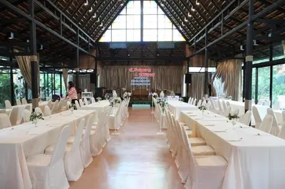 a banquet hall with white tables and white chairs at The Loft Resort Bangkok in Bangkok