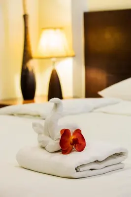 a towel with a swan and a flower on a bed at The Loft Resort Bangkok in Bangkok