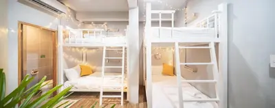 a room with two bunk beds with a couch at Better Moon Guesthouse in Bangkok