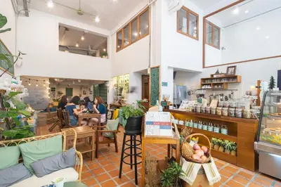 a store with people sitting at tables in a room at Better Moon Guesthouse in Bangkok