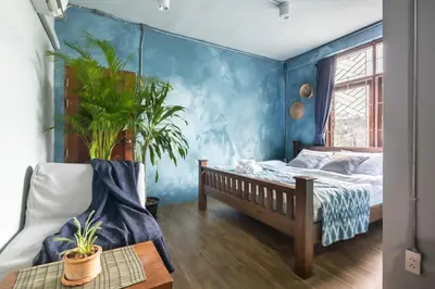 a bedroom with a bed and a blue wall at Better Moon Guesthouse in Bangkok