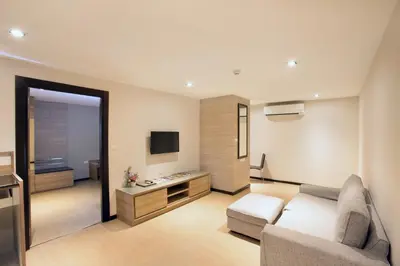 a living room with a couch and a television at Mida Hotel Ngamwongwan - SHA Plus in Nonthaburi