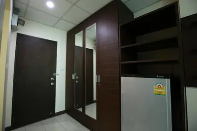 a bathroom with a mirror and a refrigerator in it at De Junction House in Bangkok