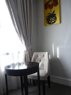 a living room with a table and a chair at Aphrodite Inn Bangkok in Bangkok